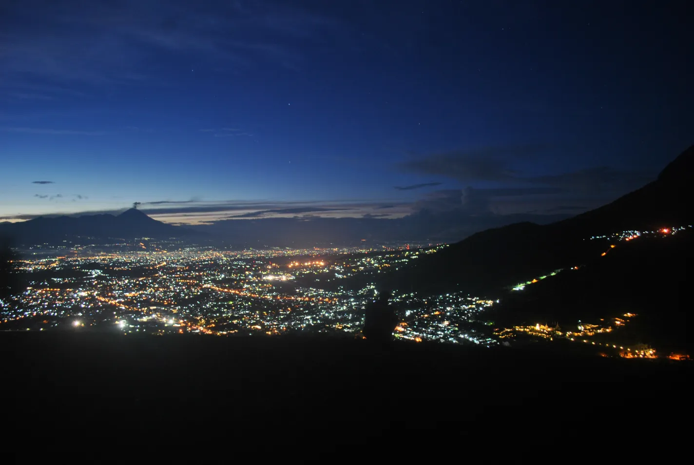 Lampu Kota Batu dan Malang dengan siluet Gunung Semeru dilihat dari Paralayang Gunung Banyak saat langit gelap