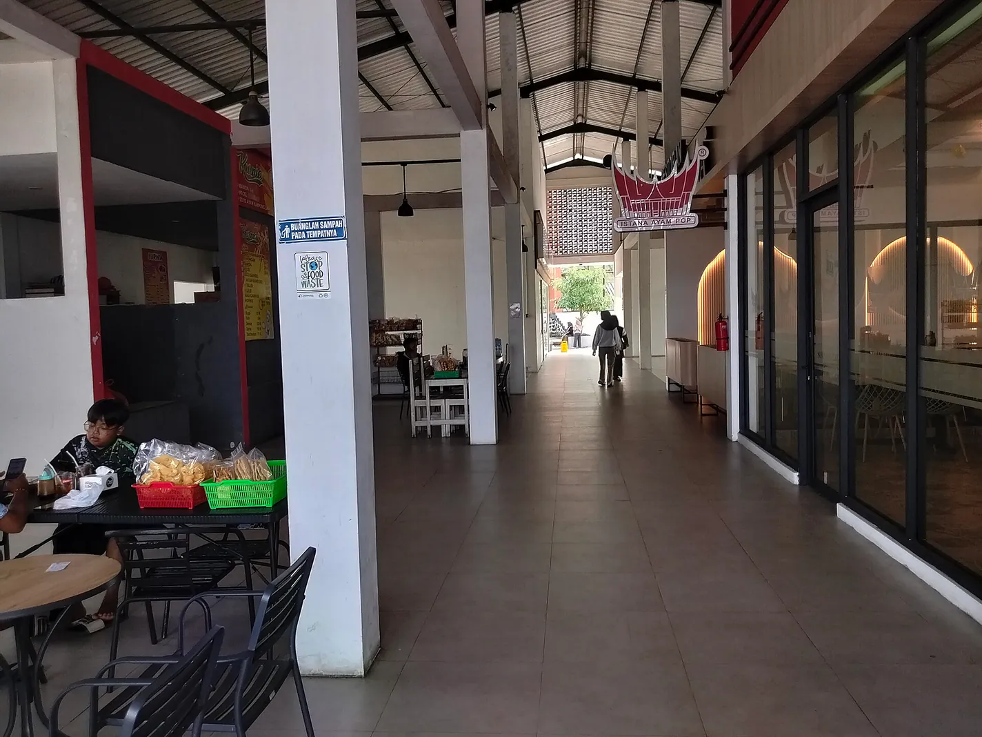 Lorong pujasera Rest Area KM 66 A Tol Pandaan-Malang dengan kios makanan dan meja