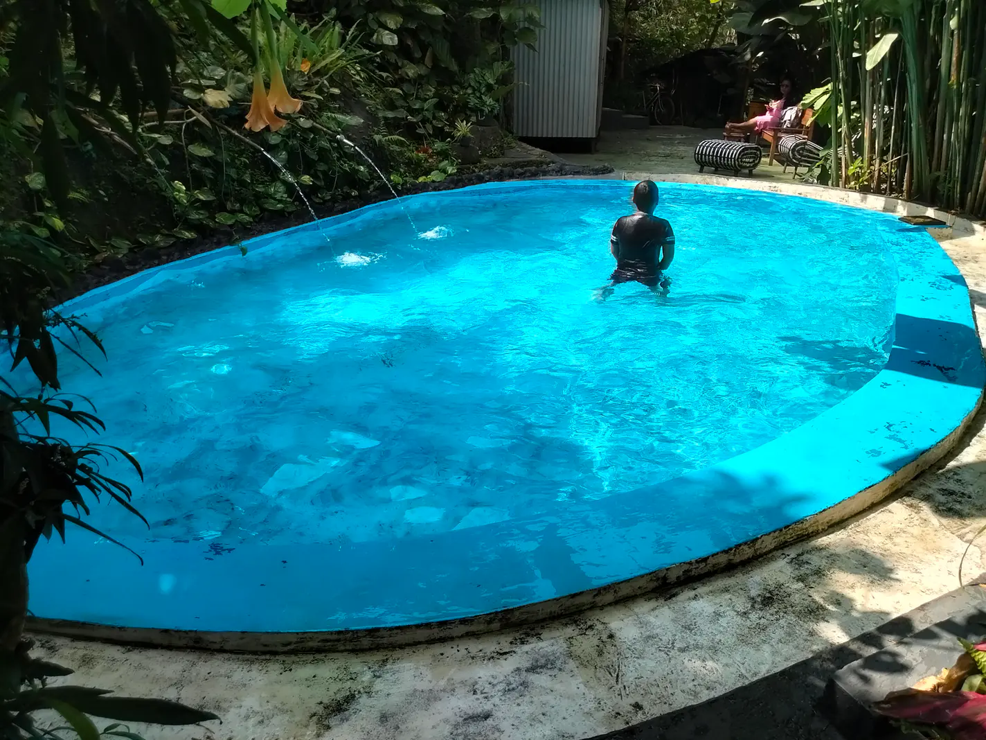 Kolam renang anak berair biru di tengah taman hijau kawasan wisata Coban Lanang