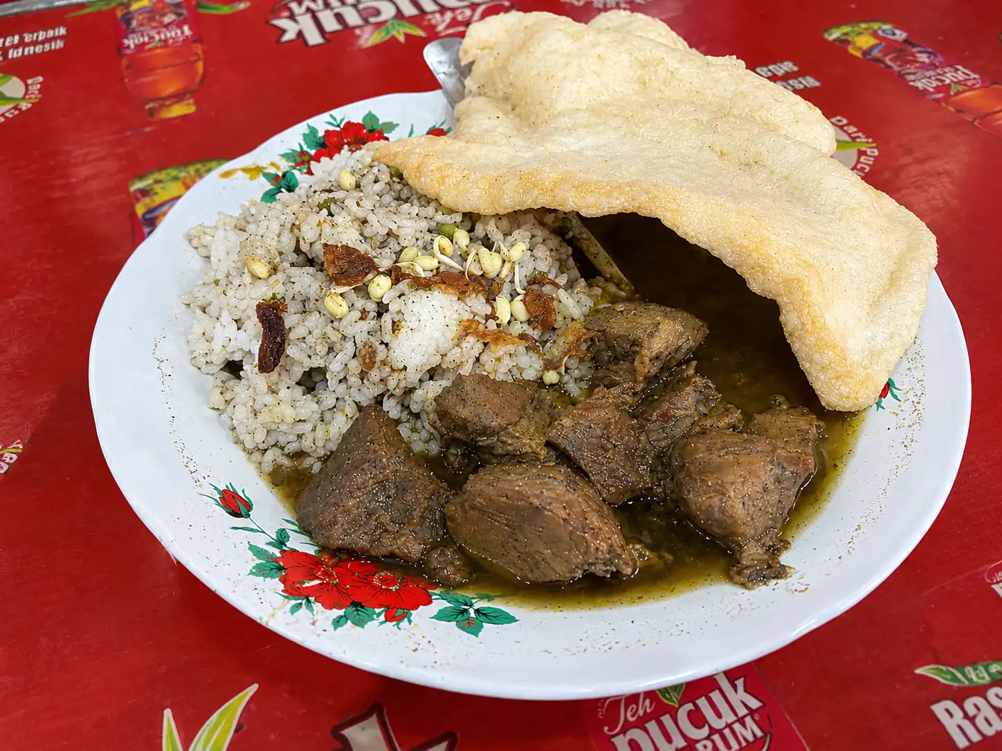 Nasi rawon campur dengan potongan daging, tauge pendek, dan kerupuk udang di Rawon Kalkulator Surabaya